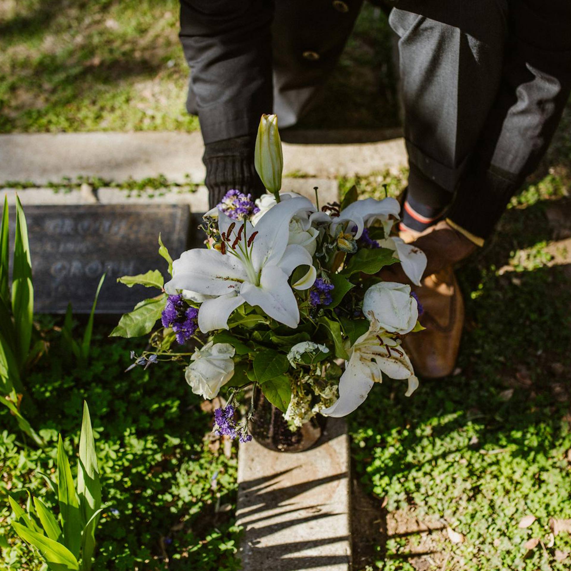 Man Placing a Bunch of Flowers on a Grave Man Placing a Bunch of Flowers on a Grave